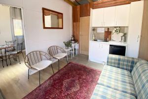 a living room with a couch and a kitchen at Off-the-grid Mountain hideaway in Hill End