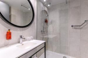 a bathroom with a sink and a shower with a mirror at Holiday Inn Hasselt, an IHG Hotel in Hasselt