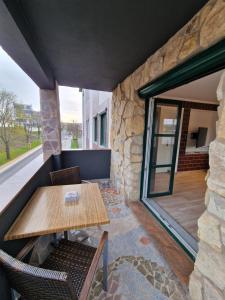 een patio met een tafel en stoelen en een stenen muur bij Spatzennest in Dresden