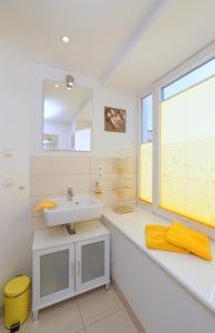 La salle de bains est pourvue d'un lavabo et d'une fenêtre. dans l'établissement APRICUM - Mein Sonnenlicht - Haus Granitz, à Binz