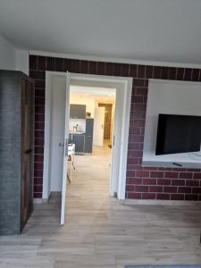 uma sala de estar com uma parede de tijolos e uma televisão em Spatzennest em Dresden