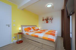 - une chambre avec un lit aux murs orange et jaune dans l'établissement APRICUM - Mein Sonnenlicht - Haus Granitz, à Binz