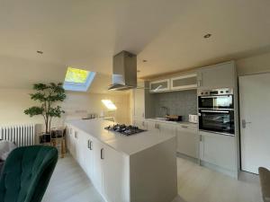 a kitchen with white cabinets and a counter top at Edge Water Cottage-recently constructed in Crawfordsburn