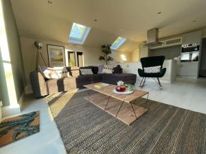 a living room with a couch and a table at Edge Water Cottage-recently constructed in Crawfordsburn