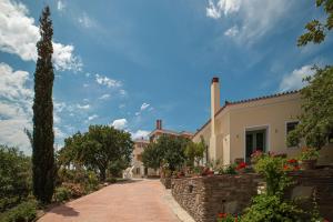 a road leading to a house with a stone wall at Armonia Resort in Ménites