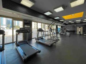 a gym with treadmills and machines in a room at Bright & Relaxing 1BR Apartment in Dubai