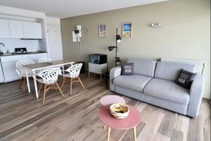 a living room with a couch and a table at Le nid de la plage in Le Touquet-Paris-Plage +17 photos