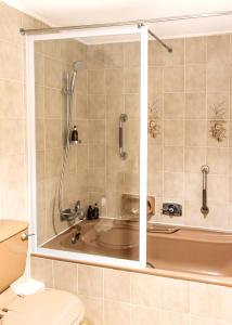 a bathroom with a bath tub and a toilet at Bayview 305A in Hermanus +14 photos