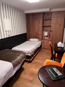 Cette chambre comprend deux lits, une table et un bureau. dans l'établissement Hôtel Ettenheim, à Strasbourg