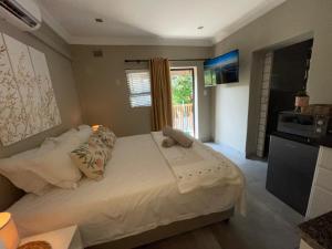 a bedroom with a large bed with a window at Guest house on Gillian Unit 5 in Ballito