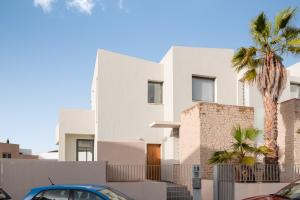 a white house with a palm tree in front of it at Karat Villa Neveda in Adeje