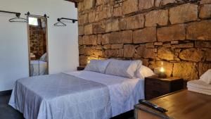 a bedroom with a bed and a stone wall at MIRADOR DE MARIA ROSA in Baños de la Encina +13 photos