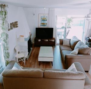 sala de estar con 2 sofás y TV en The Blue Family House, en Cabo de Palos