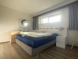 1 dormitorio con 1 cama grande con manta azul en Wijk de Brabander 61 en Cadzand