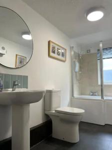 uma casa de banho com um lavatório, um WC e um espelho. em Last Yan Cottage em Ambleside