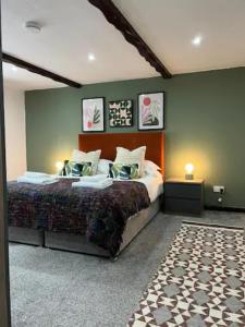 1 dormitorio con cama y pared verde en Last Yan Cottage, en Ambleside