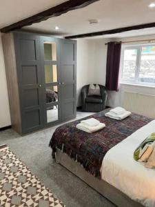 um quarto com uma cama, uma cadeira e uma janela em Last Yan Cottage em Ambleside