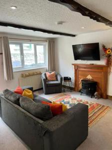 uma sala de estar com um sofá e uma lareira em Last Yan Cottage em Ambleside