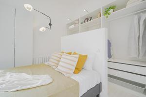 a bedroom with white walls and a bed with yellow pillows at CONT36 -Total White- Esclusive in Milan