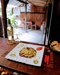 a plate of food on a table with a bottle of wine at Chez Nath in Sainte Marie