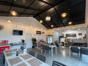 a restaurant with tables and chairs in a room at Blue Moon Boutique Resort in Sichon