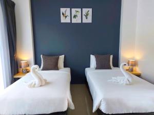 2 Betten mit Schwänen auf einem Zimmer in der Unterkunft Blue Moon Boutique Resort in Sichon