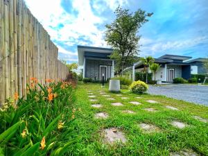 a yard with a fence and a house at Blue Moon Boutique Resort in Sichon