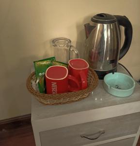 a basket on a counter with cups and a kettle at Nirvana Kuti in Kathmandu