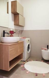 a bathroom with a sink and a washing machine at Appartamento Garden in Riccione