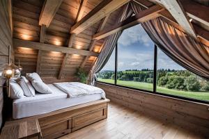 1 dormitorio con 1 cama en una habitación con ventanas en Chalet Dúška en Východná