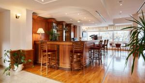 a kitchen with a bar with wooden stools at Hotel Lovran in Lovran