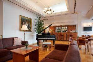 a living room with a piano and a dining room at Hotel Lovran in Lovran