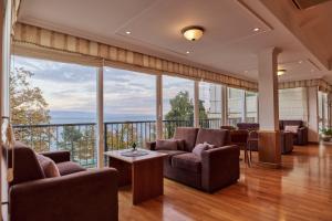a living room with couches and a balcony at Hotel Lovran in Lovran