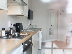 a kitchen with white cabinets and a counter top at PG McQuaid Suite in Dungannon