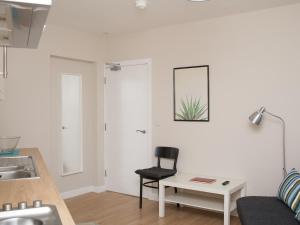 a living room with a black chair and a table at PG McQuaid Suite in Dungannon