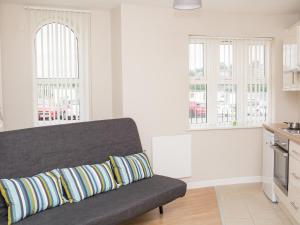 a living room with a couch and two windows at PG McQuaid Suite in Dungannon