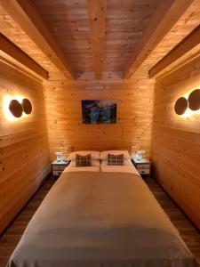 um quarto com uma cama grande num quarto de madeira em Alpenburg Bergparadies Apartments em Wald am Arlberg