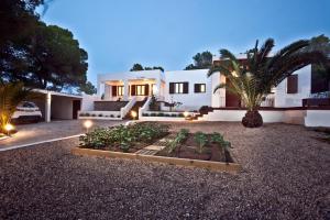 a house with a garden in front of it at Santerra - San Jose in Cala Bassa