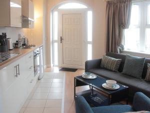 cocina y sala de estar con sofá y mesa en The Otton Suite, en Dungannon