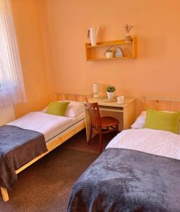 a bedroom with two beds and a table with a chair at Penzion Brtnice in Brtnice