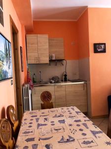 cocina con mesa y cocina con paredes de color naranja en One bedroom apartement with terrace at Bersezio 1 km away from the slopes, 
