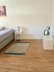 1 dormitorio con cama, mesa y alfombra en Urlaub beim Winzer, en Klingenmünster