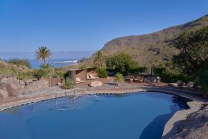 a large swimming pool with a mountain in the background at Redondo de Guayedra in Guayedra
