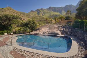 a swimming pool with a mountain in the background at Redondo de Guayedra in Guayedra