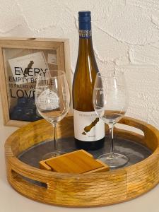 bandeja de madera con una botella de vino y dos copas en Urlaub beim Winzer, en Klingenmünster