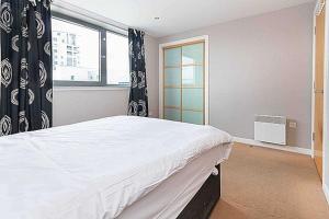 Un dormitorio con una cama grande y una ventana en Modern 2 bed apartment with stunning seaside view en Edimburgo