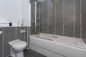 y baño con aseo, bañera y lavamanos. en Modern 2 bed apartment with stunning seaside view en Edimburgo
