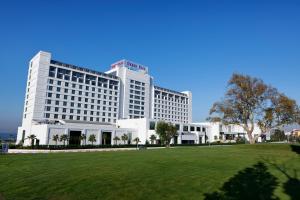 - un grand bâtiment blanc avec un parc en face dans l'établissement The Green Park Pendik, à Istanbul