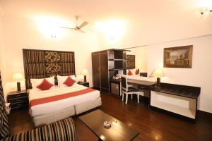 a hotel room with a bed and a desk and a desk at Hotel Capitol Hills - Greater Kailash Delhi in New Delhi