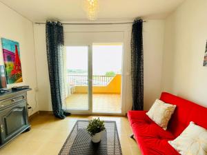 un soggiorno con divano rosso e porta scorrevole in vetro di ROMINA 4E - Apartamento en los canales de Roses Santa Margarita - terraza con vistas a Roses